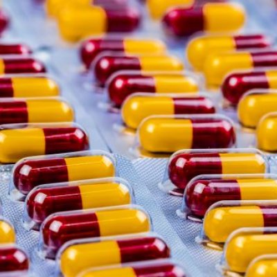 Rows of maroon and yellow capsule medication in blister packs